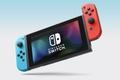The black Nintendo Switch OLED with a blue controller connected on the left, and a red one on the right.