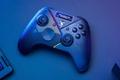 A black controller with gradient multicolored lighting zig-zagging through the center of it.